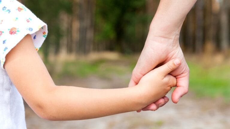 Parent holding a child's hand